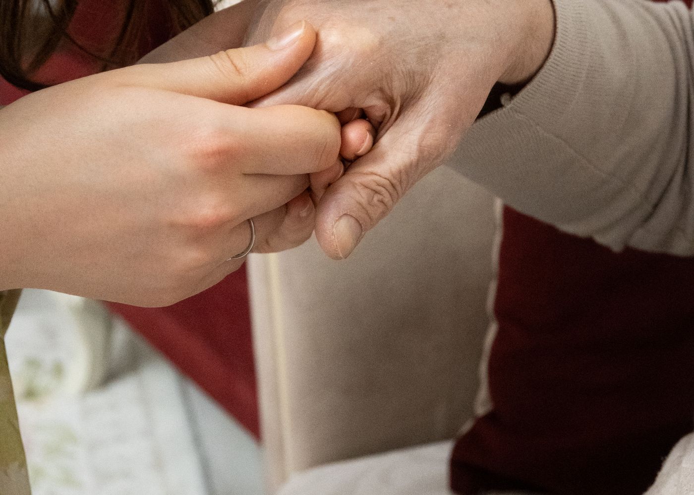 Pflegekraft hält die Hand einer älteren Person